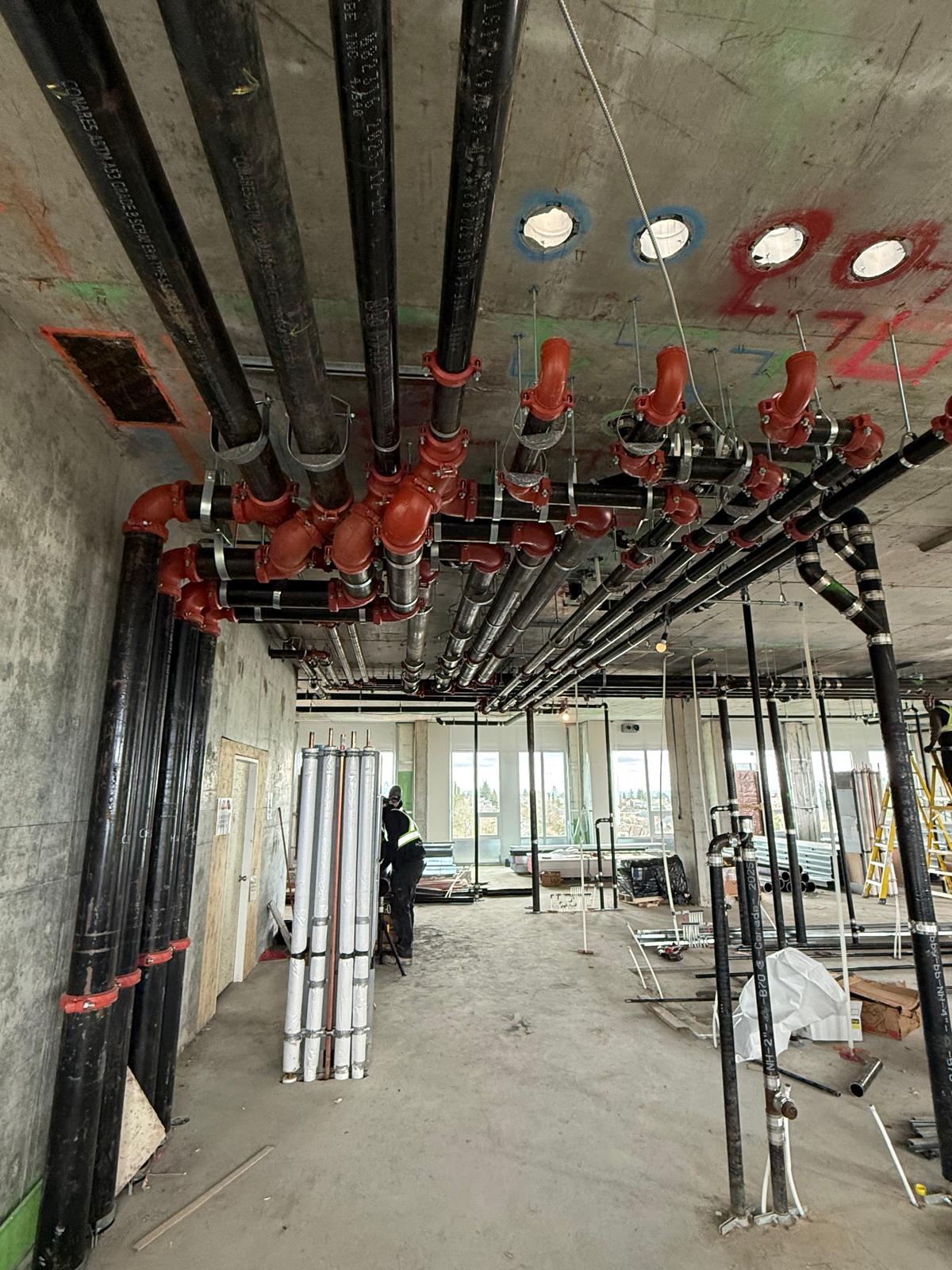 Archpro crew working around red piping installation